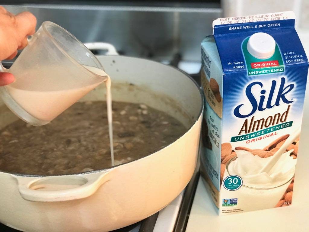 Silk almond unsweetened being poured into mushroom stroganoff